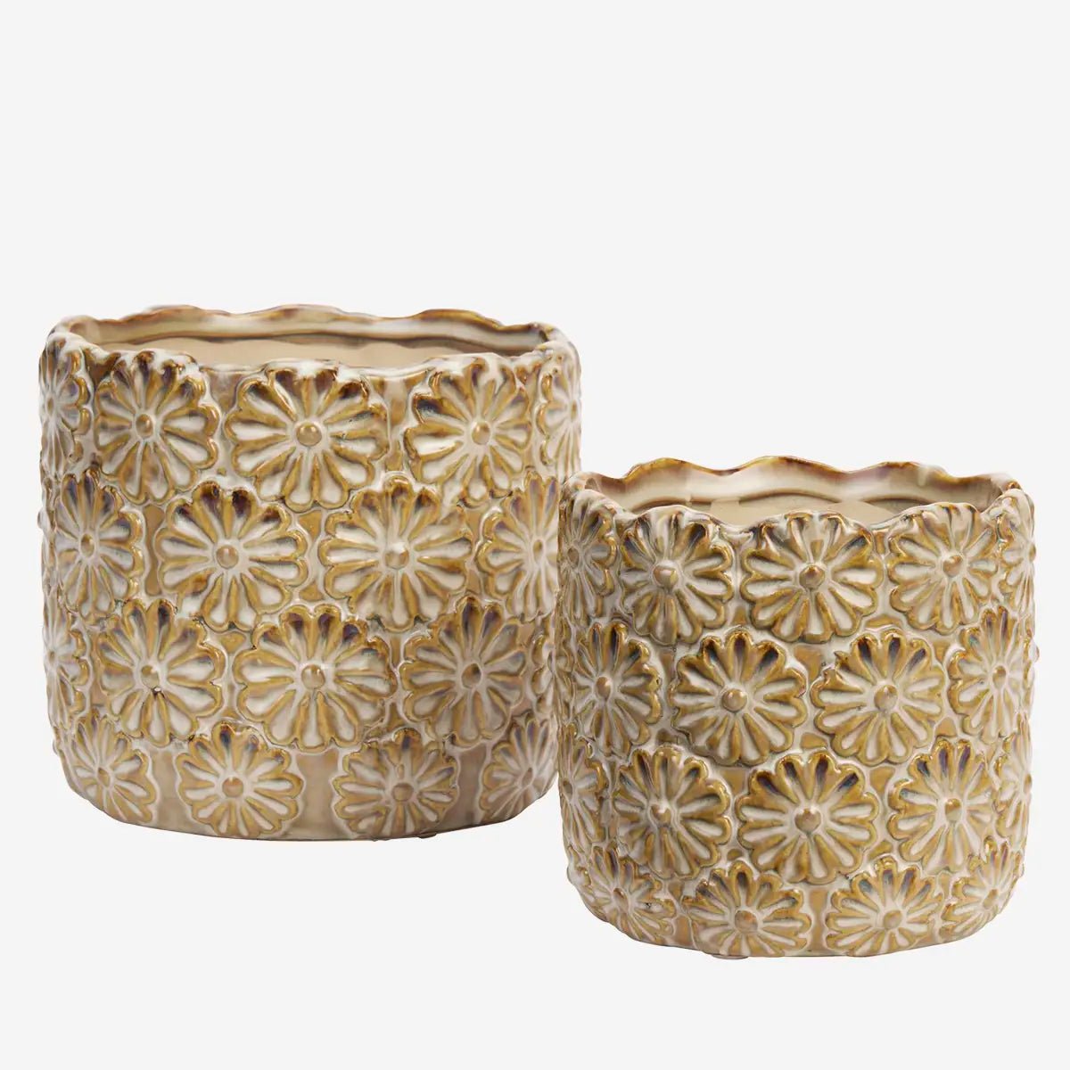 De potten zijn vervaardigd uit steengoed en afgewerkt met een reactief glazuur in zand- en off white tinten. Met verfijnde reliëf van bloemmotieven.