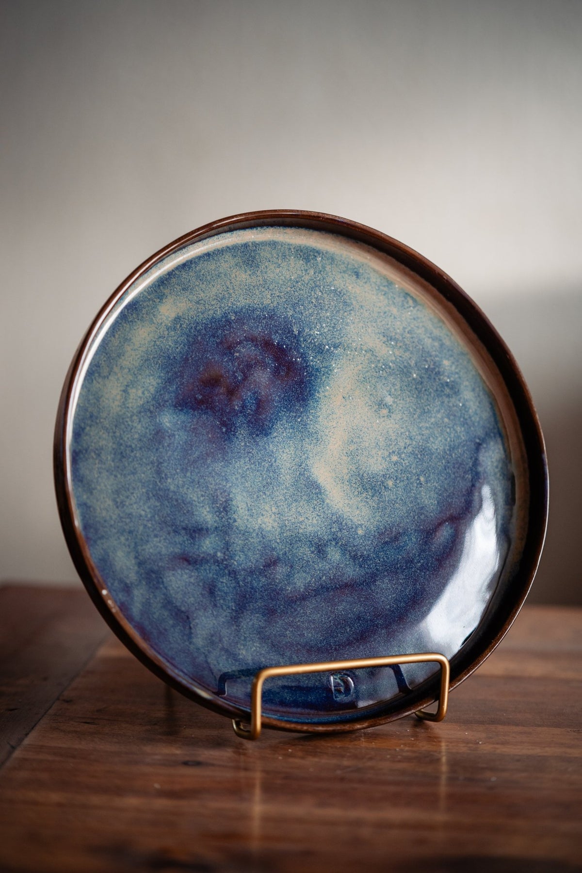 Keramieken dinerbord met blauw reactief glazuur en paarse en cremekleurige nuances.