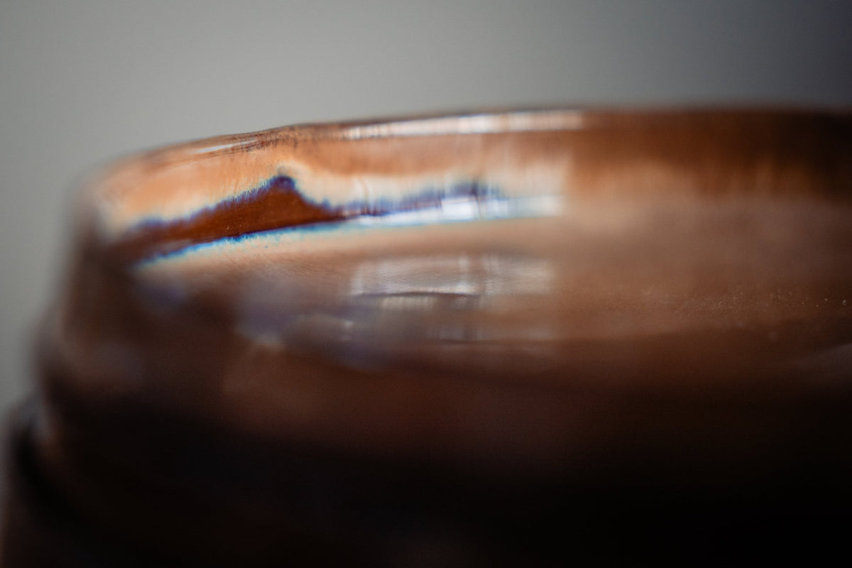 Close-up van het glazuurverloop op een keramieken bord, van koper naar blauw.