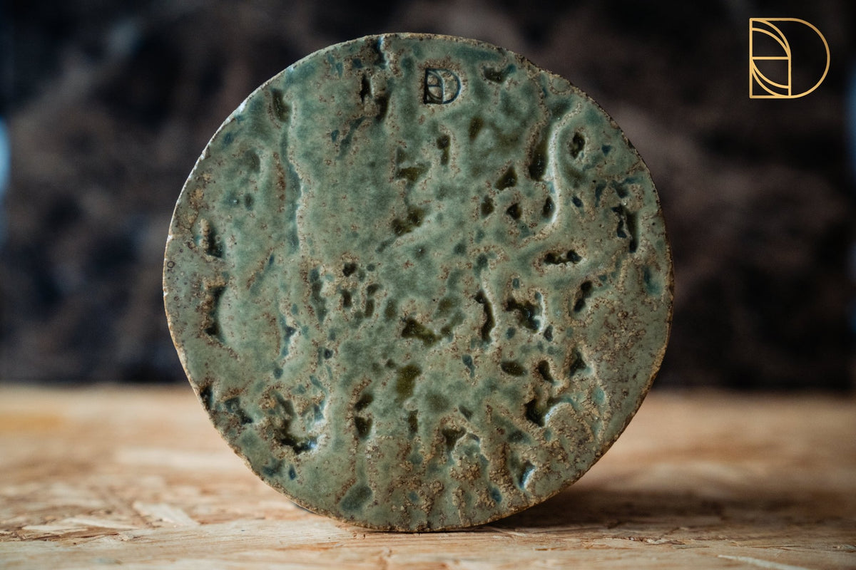 Groen keramieken bordje met een reliefafdruk van boomschors en jadegroen glazuur.