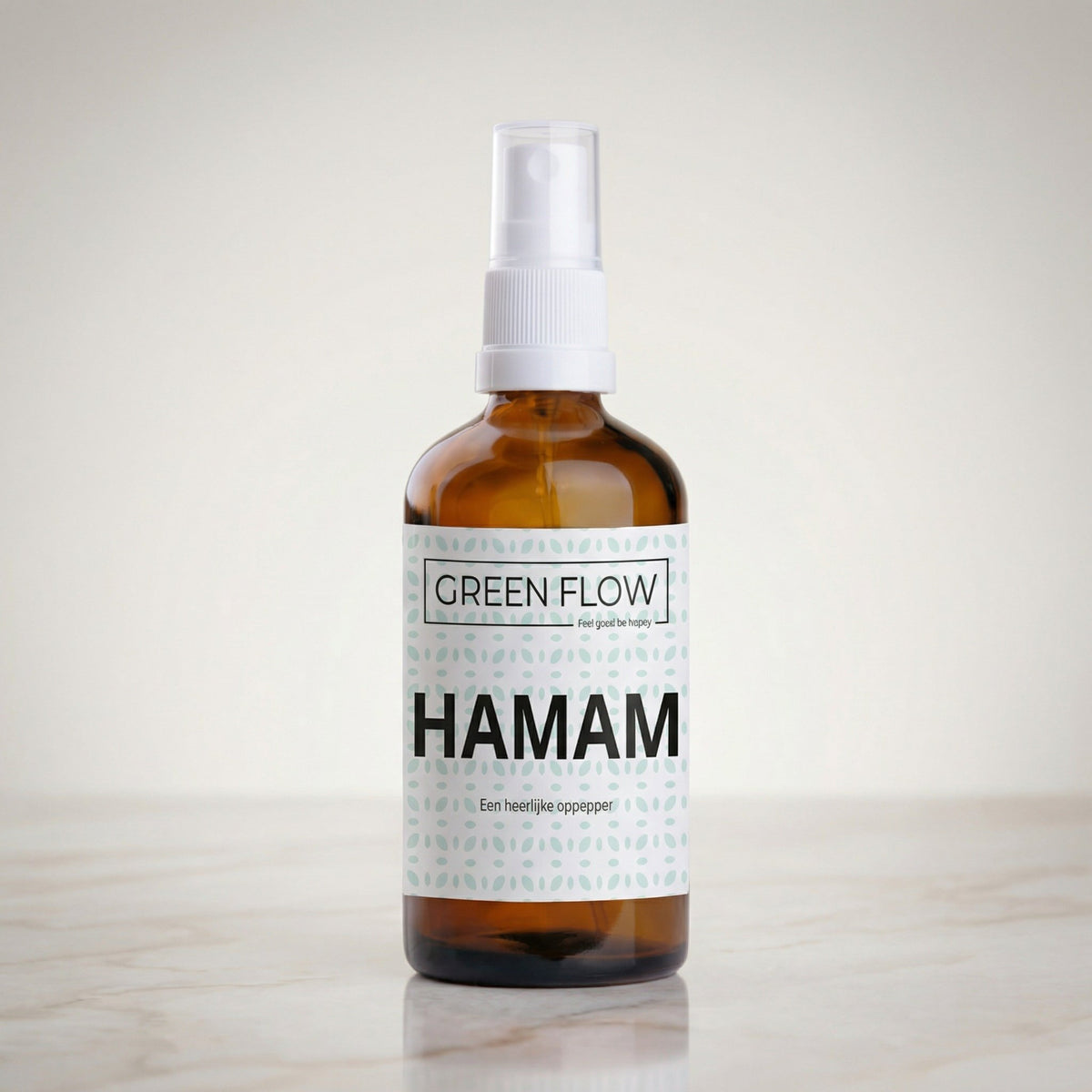 Bruin glazen verstuiver van 100 ml met witte sproeikop op een marmeren blad.