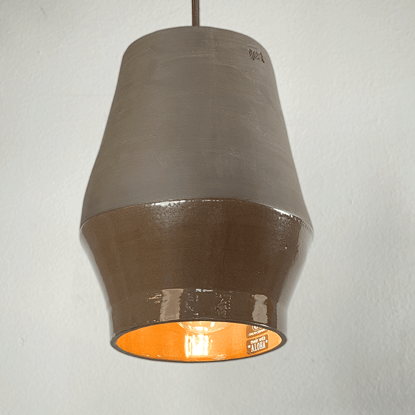 Tonvormige keramieken hanglamp met chocoladebruin glazuur en brandende lamp.