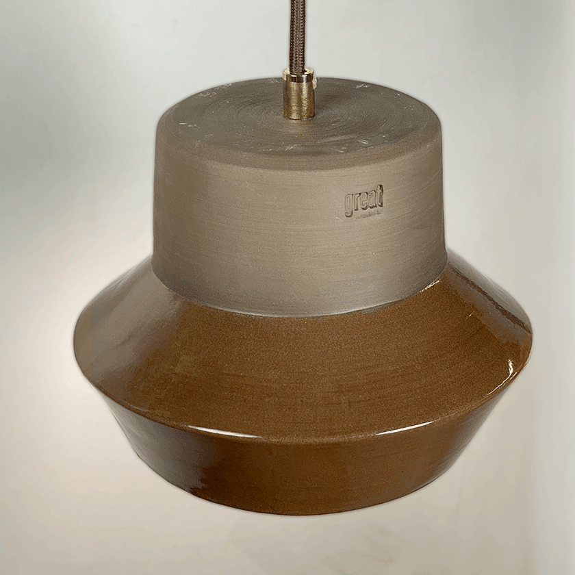 Keramieken hanglamp met chocoladebruin glazuur boven een keukenblad.