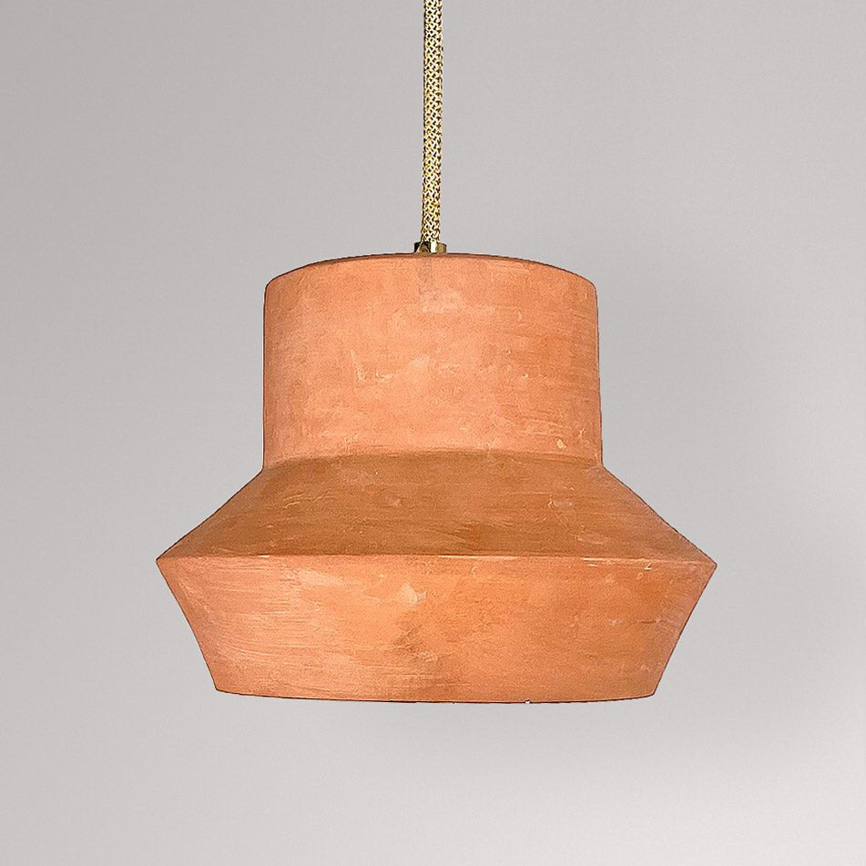 Brede, lage keramieken hanglamp in terracotta aan een goudkleurig textielsnoer.