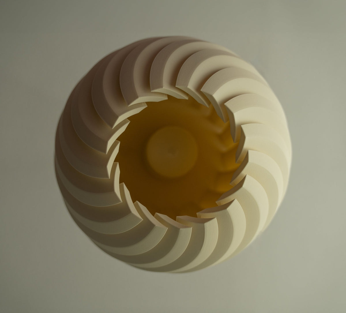 Bolvormige lampenkap van onderaf gezien met het golfreliëf rond de verlichte opening.