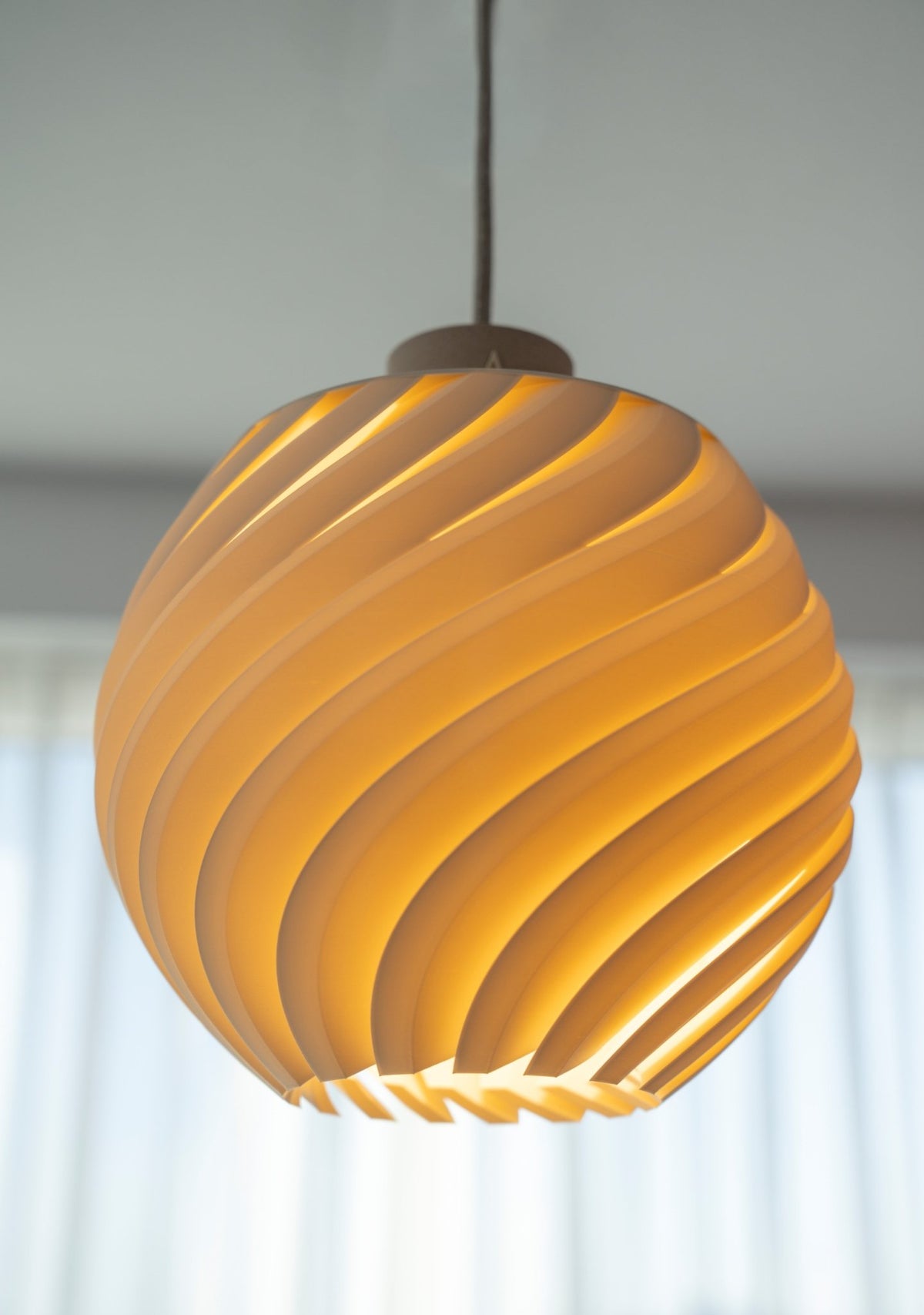 Brandende bolvormige lampenkap met dicht golfreliëf van dichtbij, warm oplichtend.