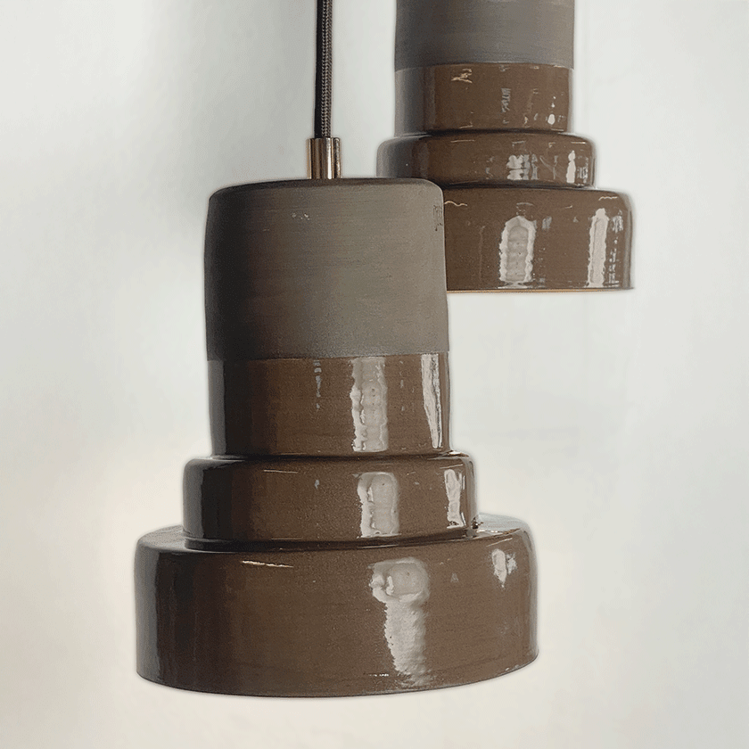 Twee getrapte keramieken hanglampen met glanzend chocoladebruin glazuur.