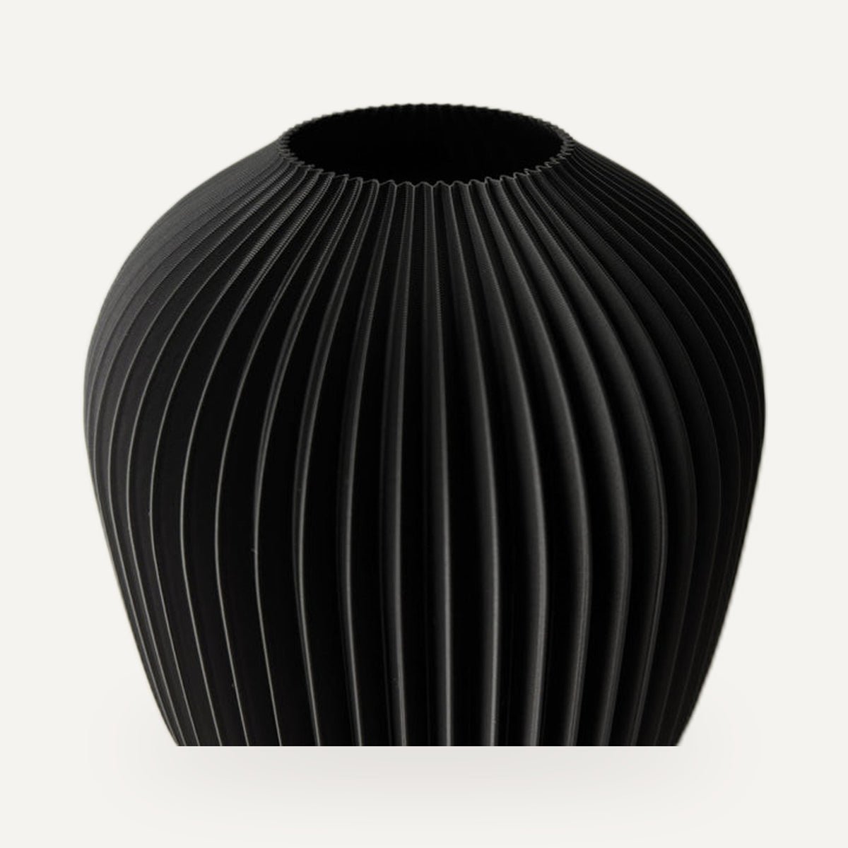 Vaas in mat zwart met verticale ribbels en een brede bolle romp.