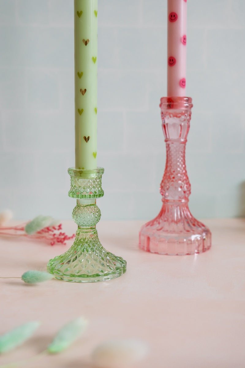 Deze complete set bestaat uit twee ledkaarsen met subtiele roze hartjes en twee stijlvolle glazen kandelaren in verschillende kleuren