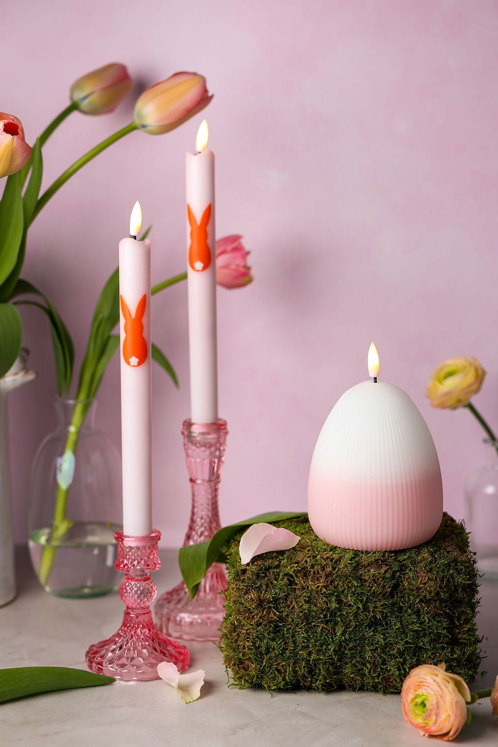 Twee elegante ledkaarsen met subtiele roze hartjes, een stijlvolle ledkaars Eggy en twee roze glazen kandelaren.