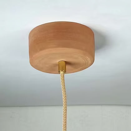 Ronde terracotta plafondkap van keramiek met messing doorvoer en goudkleurig snoer.
