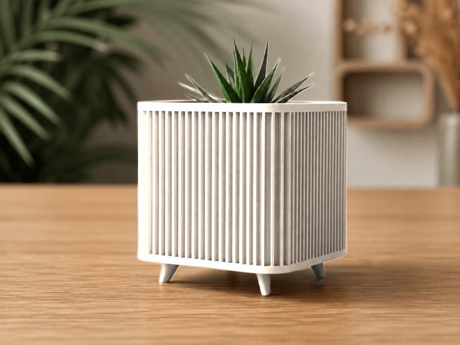 Vierkante plantenpot op pootjes in mat wit met verticale ribbels, met een vetplant.