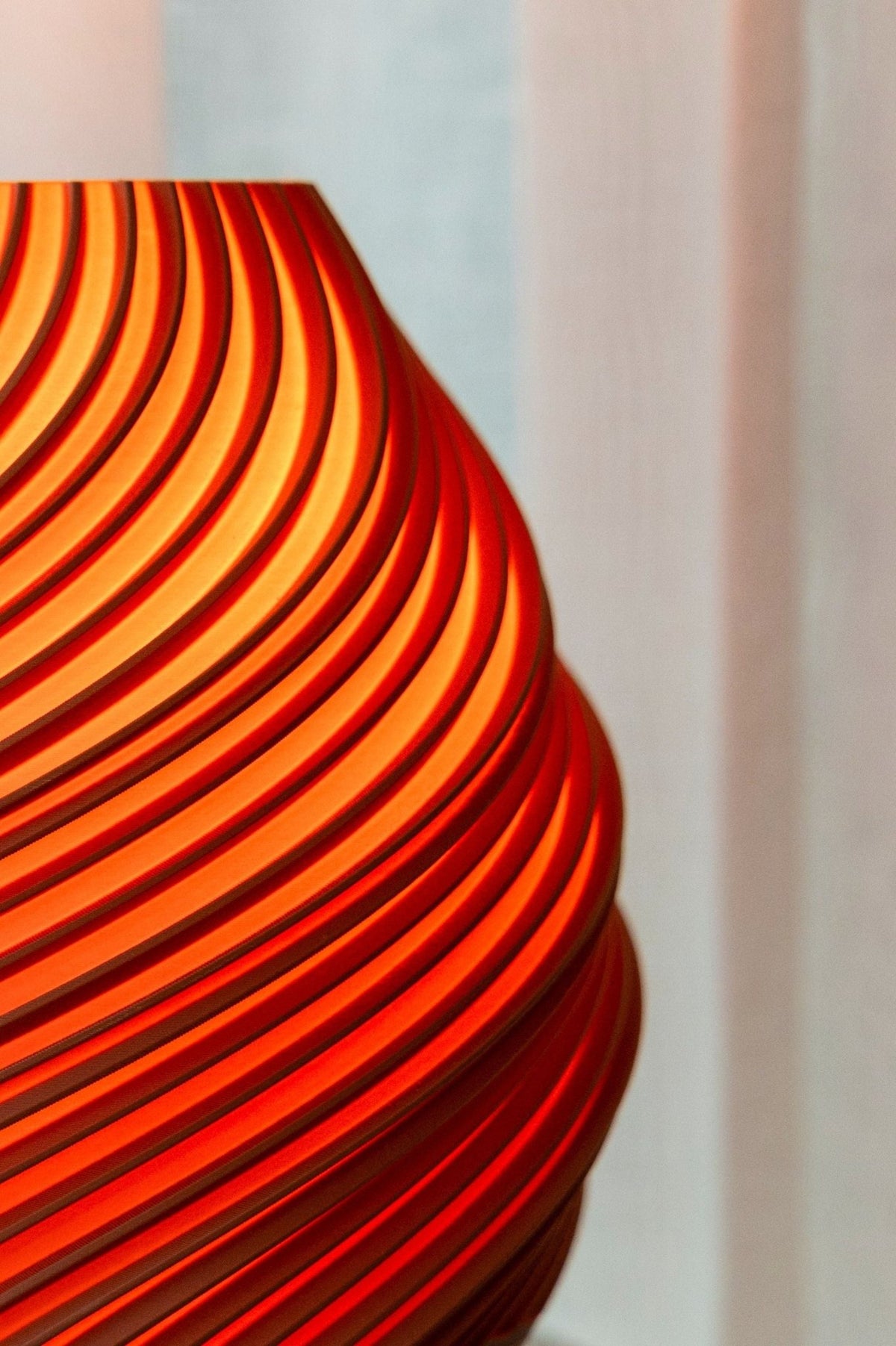 Detail van de baksteenrode gedraaide ribbels met warm licht dat er tussendoor valt.