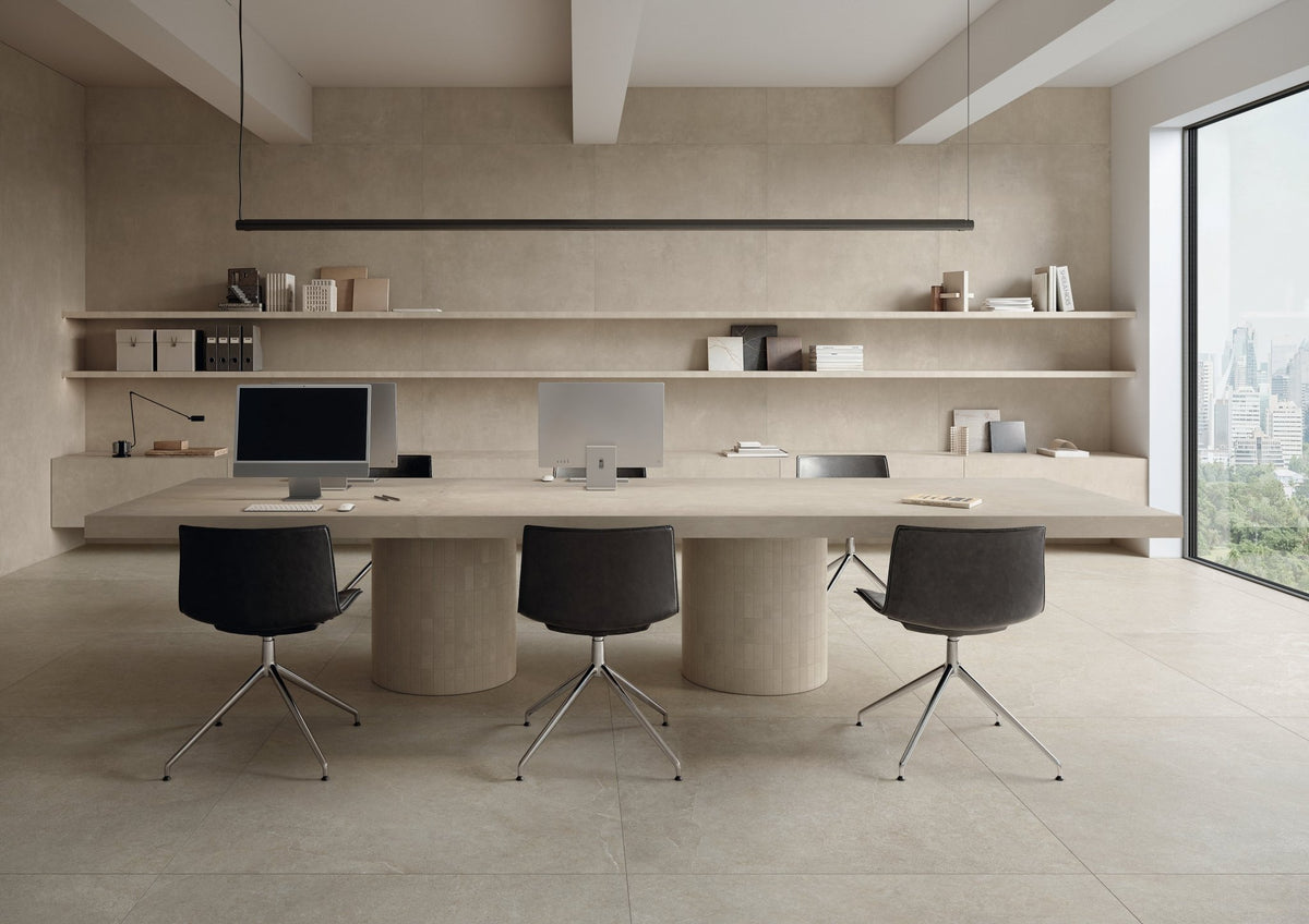 Kantoorruimte met beige betonlook vloer, ovale vergadertafel en zwarte bureaustoelen.