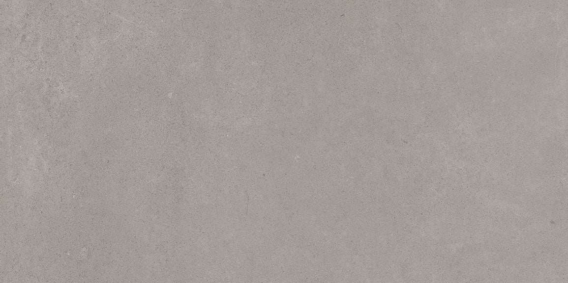Detail van een grijze betonlook vloertegel met matte afwerking.