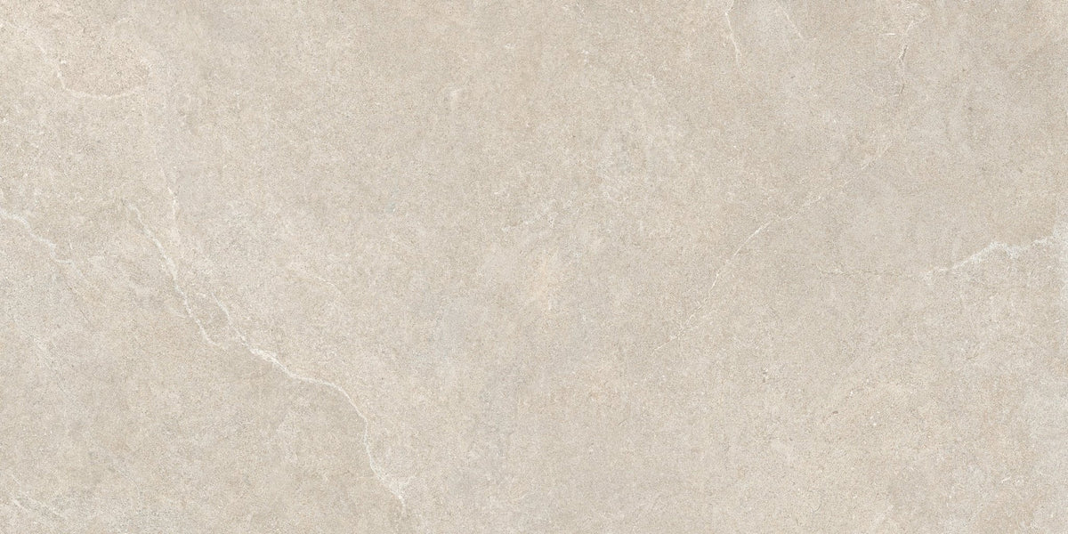 Detail van een beige kalksteenlook vloertegel met matte afwerking.