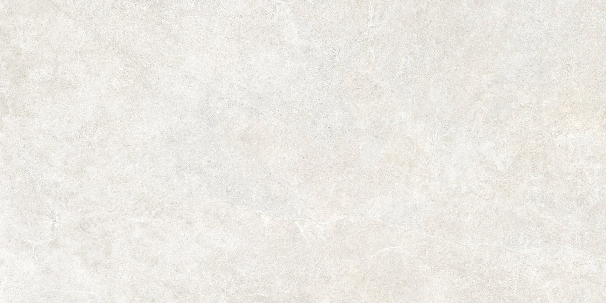 Detail van een witte kalksteenlook vloertegel met matte afwerking.