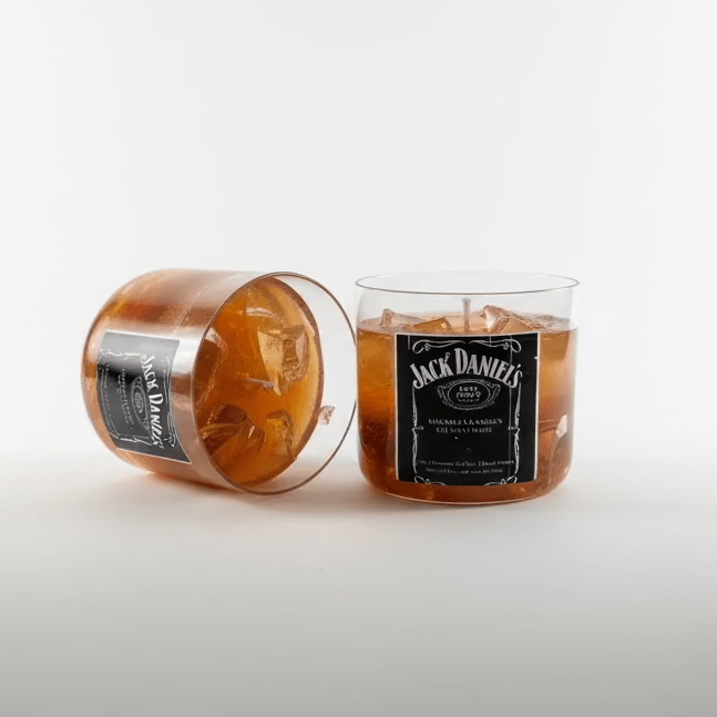 Twee gelkaarsen in whiskeyglazen met ijsblokjes van gelwas, één liggend