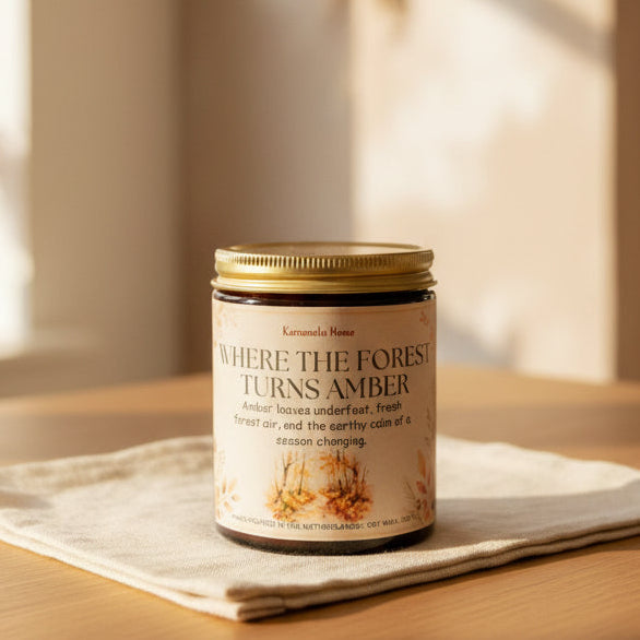 Geurkaars in een amberkleurige glazen pot met gouden deksel op een linnen doek