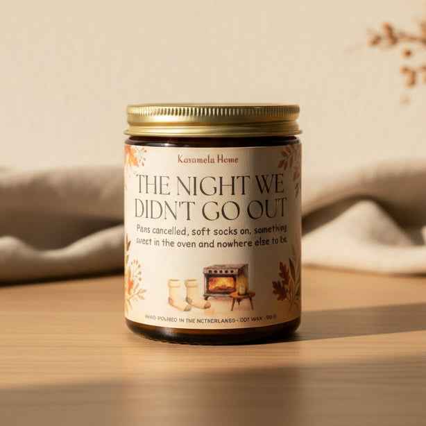 Geurkaars in amberkleurig glas met gouden deksel en een crème etiket met houtkacheltje