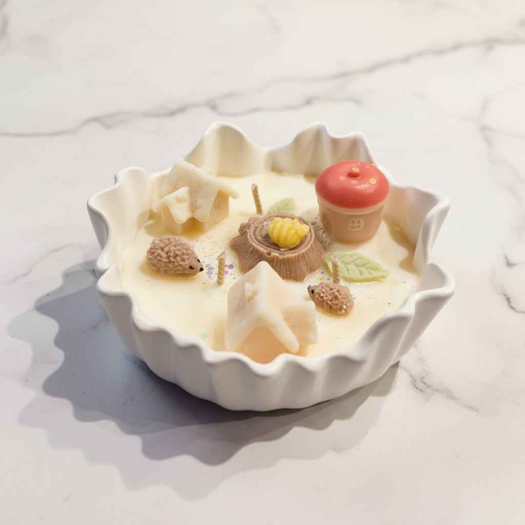 Geurkaars in een crème keramieken schaal met huisjes, egeltjes en een rode appel van was