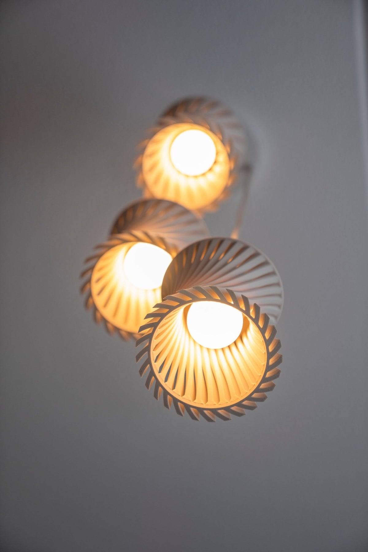 Drie geribbelde lampenkappen van onderaf met brandende ledlampen in de openingen.