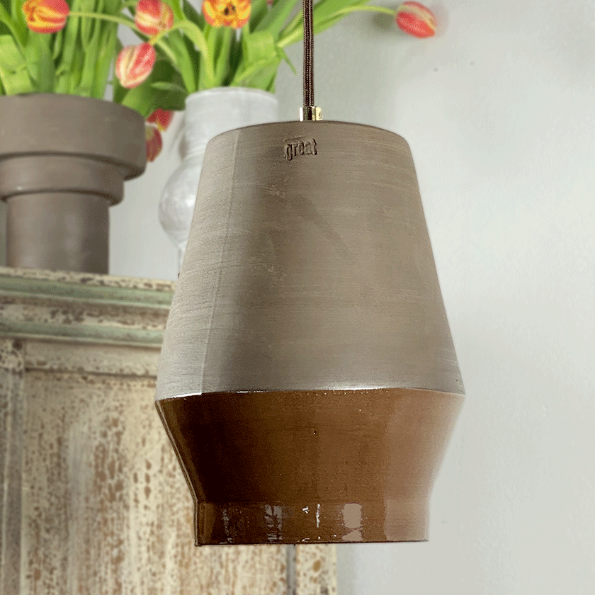 Keramieken hanglamp met chocoladebruin glazuur bij een boeket tulpen.