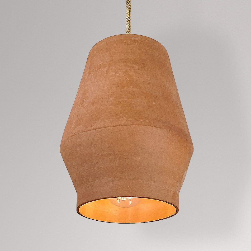 Tonvormige keramieken hanglamp in terracotta met brandende lamp.