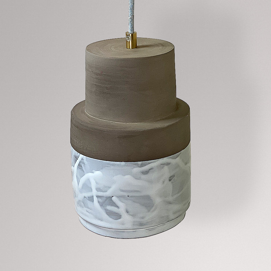 Cilindrische keramieken hanglamp met grijze bovenkant en wit gemarmerd glazuur.