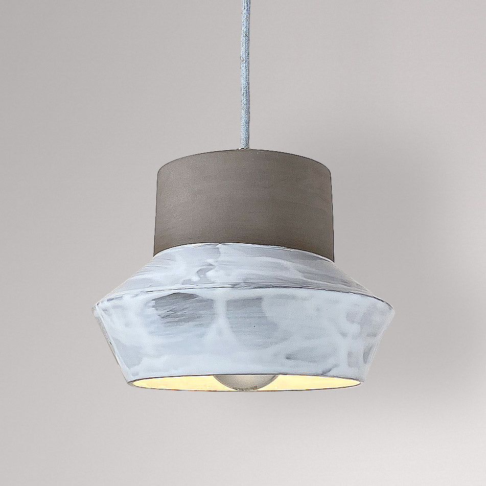 Brede keramieken hanglamp met wit gemarmerd glazuur en brandende lamp.