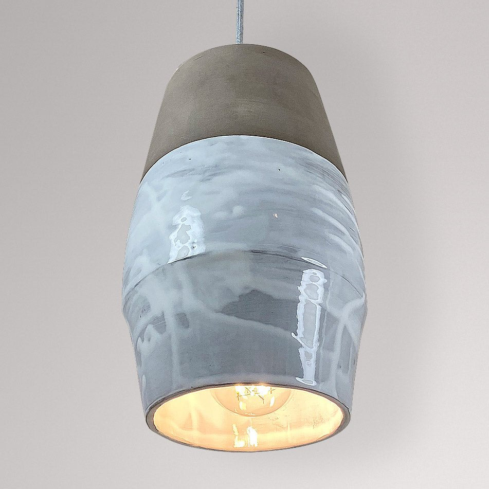 Ovale keramieken hanglamp met wit gemarmerd glazuur en brandende lamp.