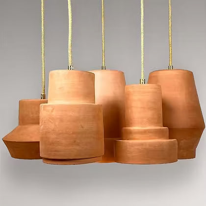 Vijf keramieken hanglampen in terracotta in verschillende modellen bij elkaar.