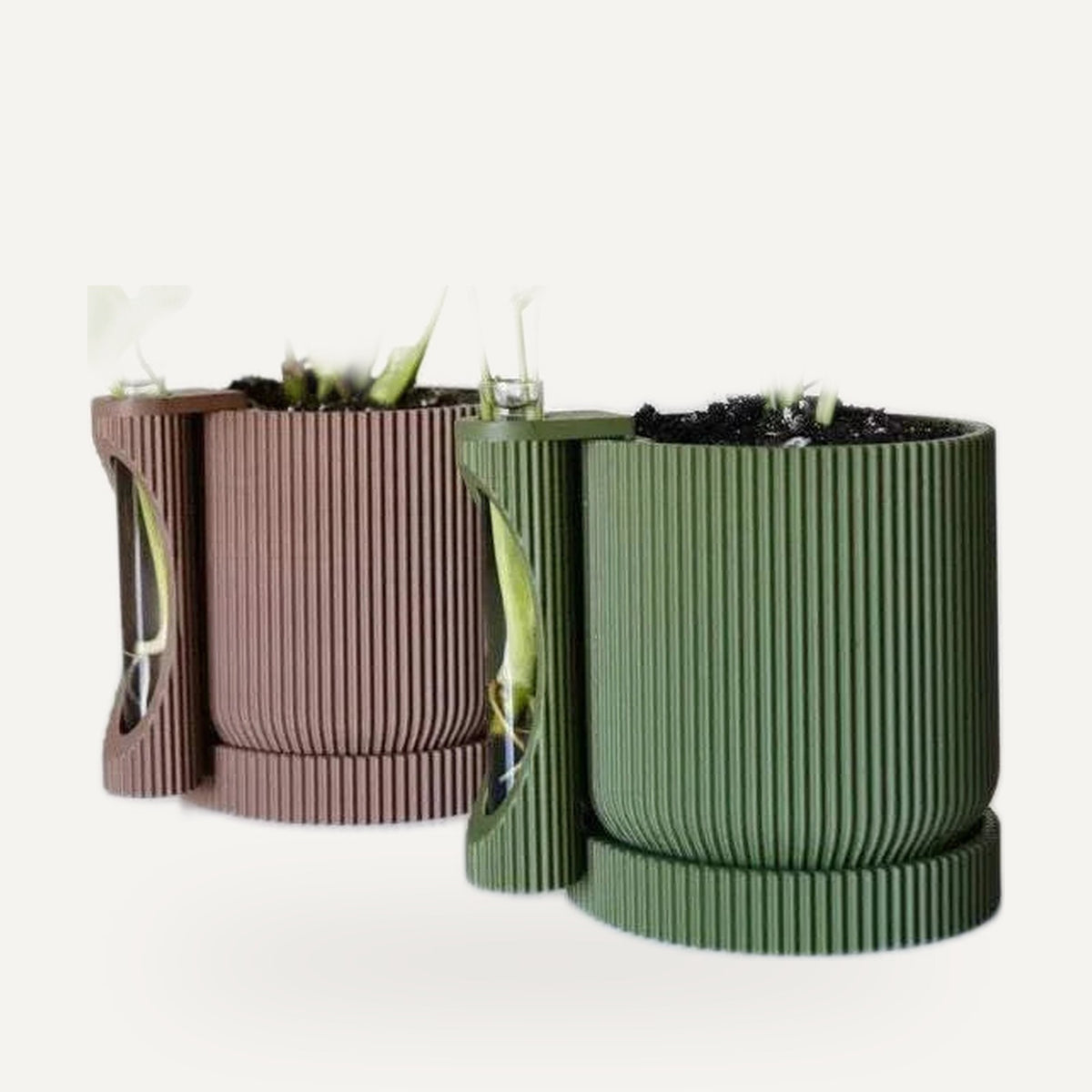 Plantenpotten met stekhouder naast elkaar in terracotta en groen, met jonge stekjes.