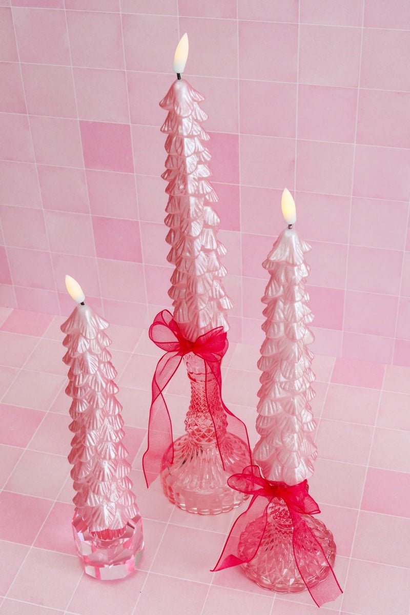 De slanke kerstboomvorm met gelaagde details en een glanzende metallic roze afwerking maakt deze kaarsen tot echte blikvangers, zowel aan als uit.