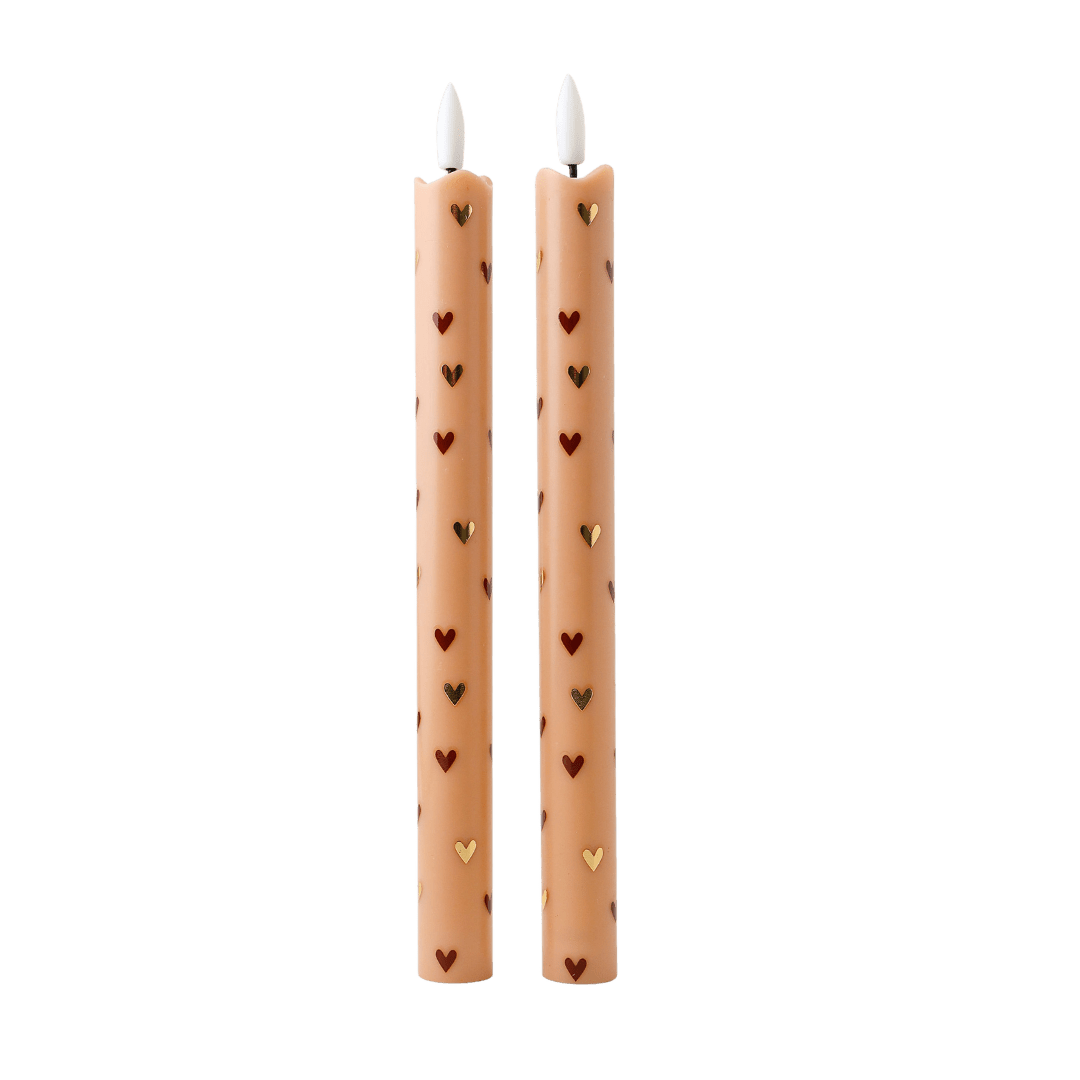  Deze elegante set van twee ledkaarsen is uitgevoerd in een zachte zandkleur en afgewerkt met subtiele gouden en bruine hartjes. 