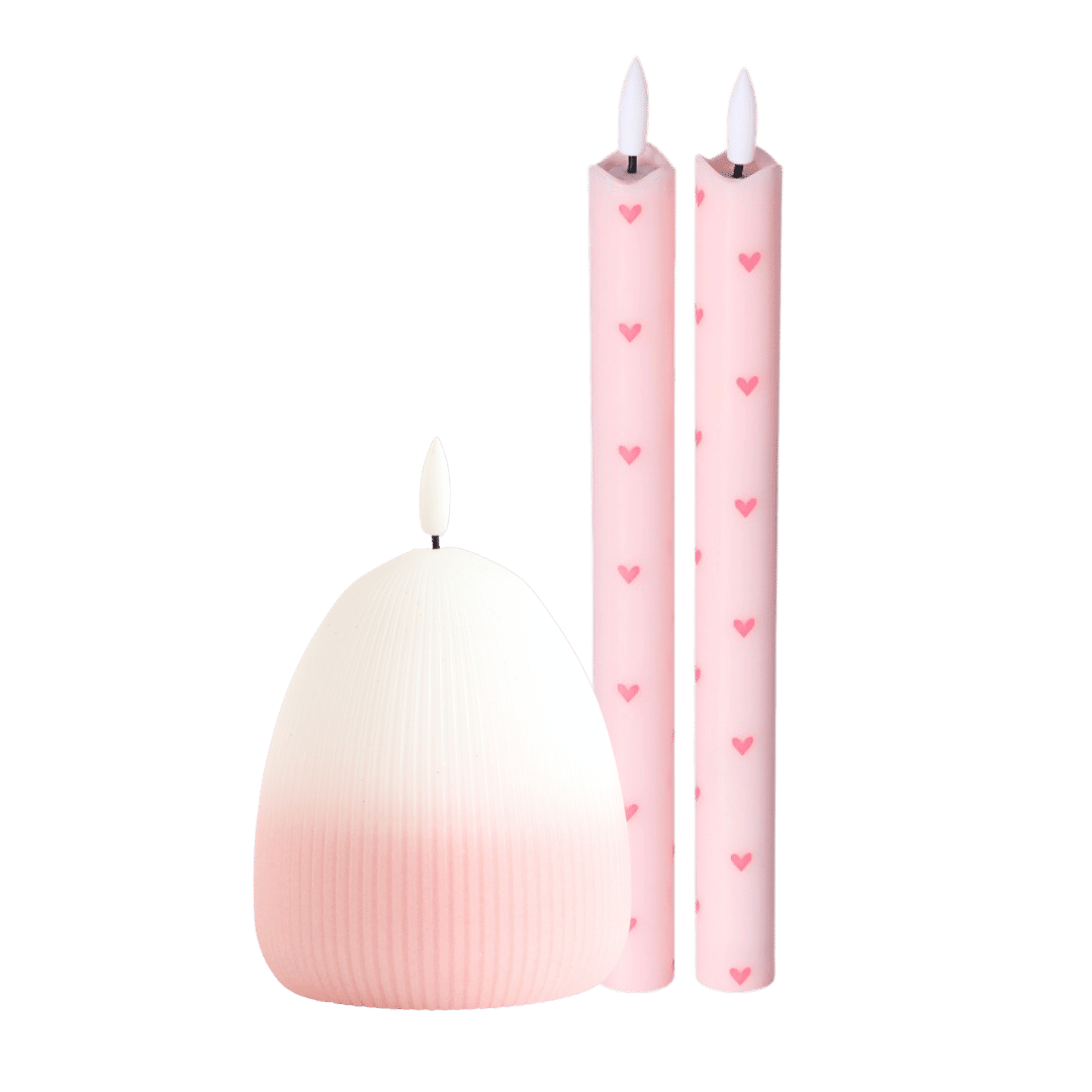  twee elegante ledkaarsen met subtiele hartjes en de speelse ledkaars Eggy in een zacht roze kleurverloop. 
