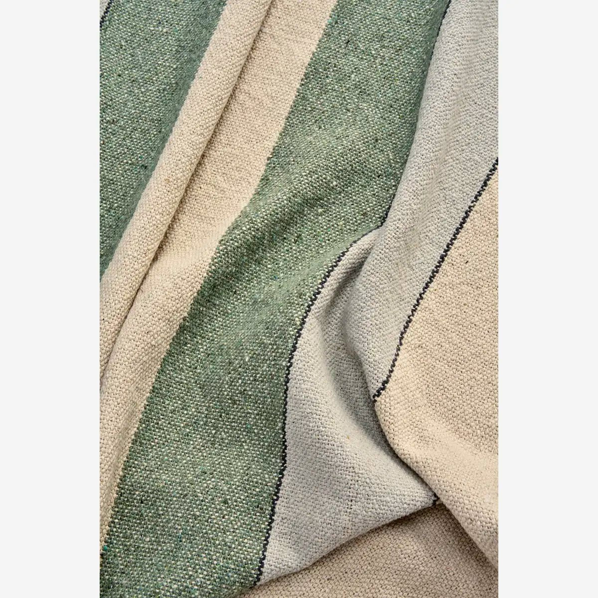 Deze groen beige plaid is handgeweven en gemaakt van gerecycled materiaal