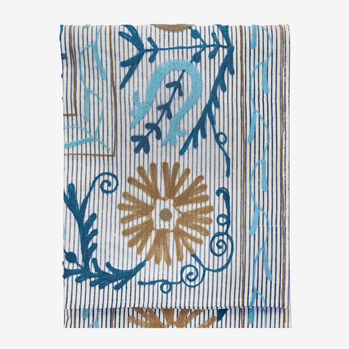 De kleuren blauw, greige, zand en off-white zorgen voor een harmonieus geheel, terwijl het reliëf van het borduurwerk diepte en karakter toevoegt.