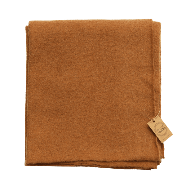 Opgevouwen plaid van warm roestbruine gekookte wol met een gemêleerde structuur.