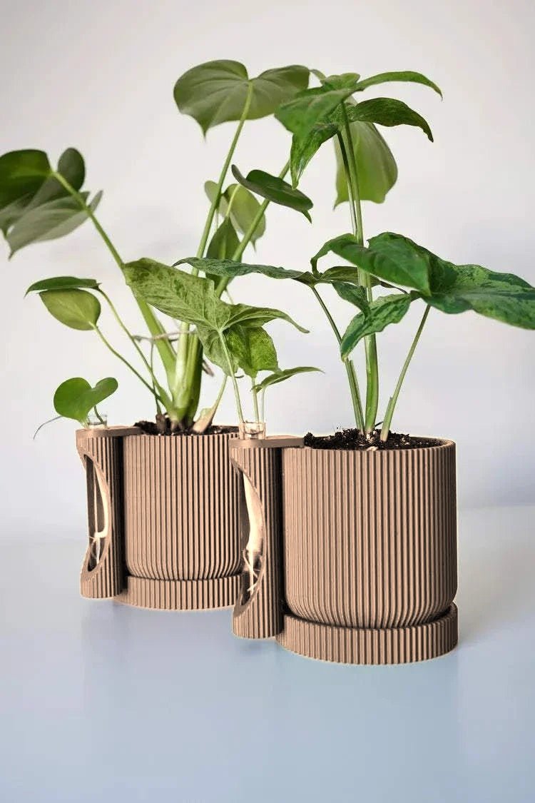 Twee geribbelde plantenpotten met stekhouder in zandbeige, beplant met een monstera.