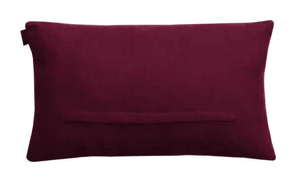 Achterzijde van het ikat-kussen: effen bordeaux stof met horizontale sluiting.