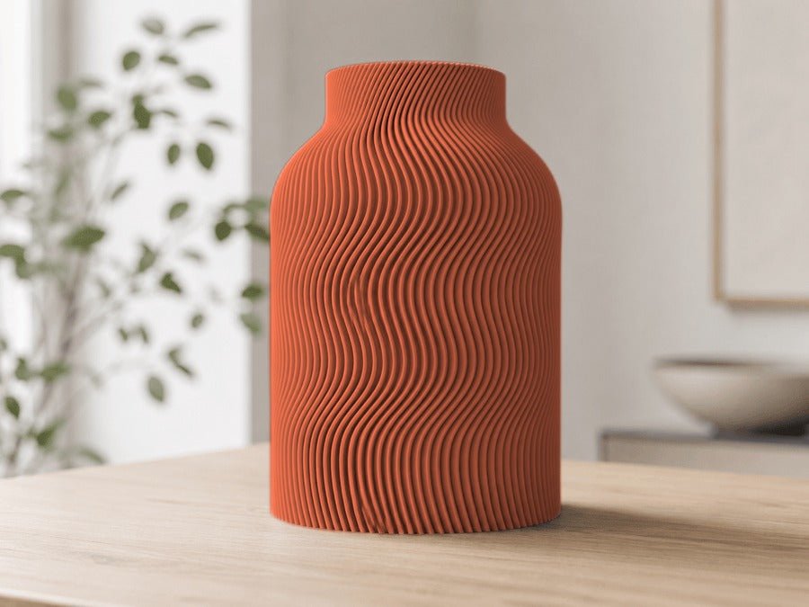 Vaas met golvende ribbels in terracotta op een houten tafel.