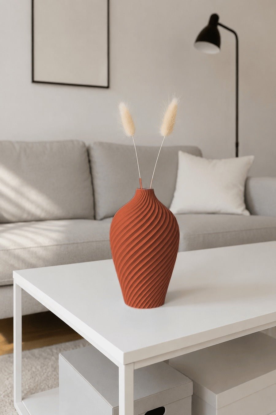 Vaas met doorlopend spiraalpatroon in terracotta op een witte salontafel.