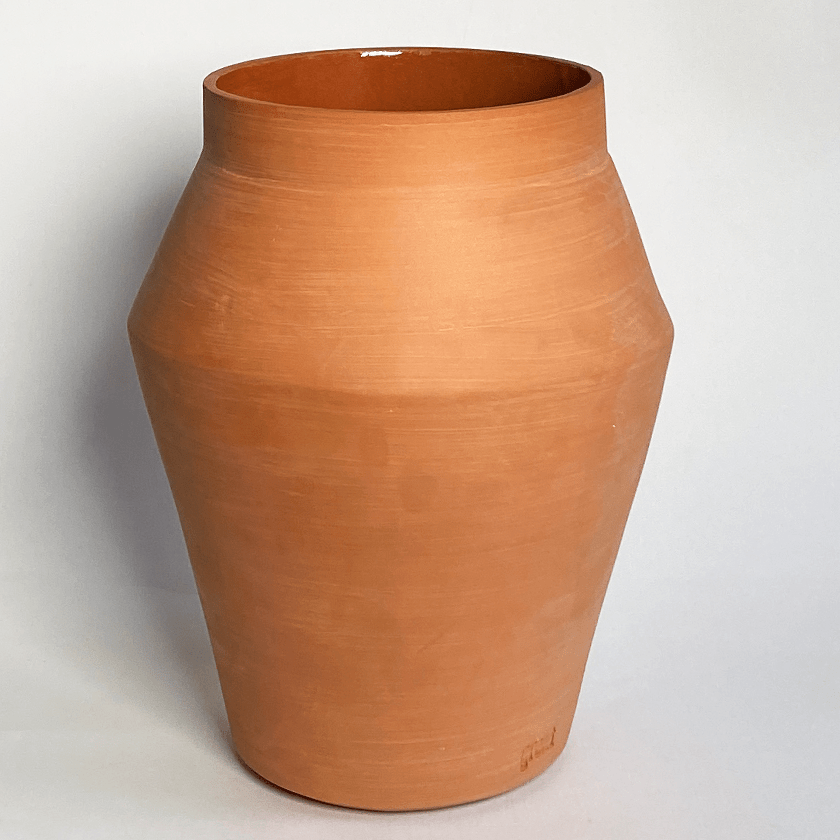 Keramieken vaas in terracotta met een hoekige schouder en versmallende voet.